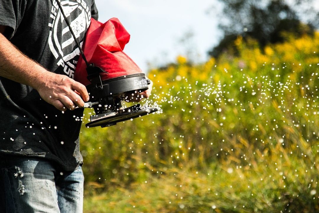 Close-up of someone using a spreader to spread seed, hunt deer in hot weather concept. 