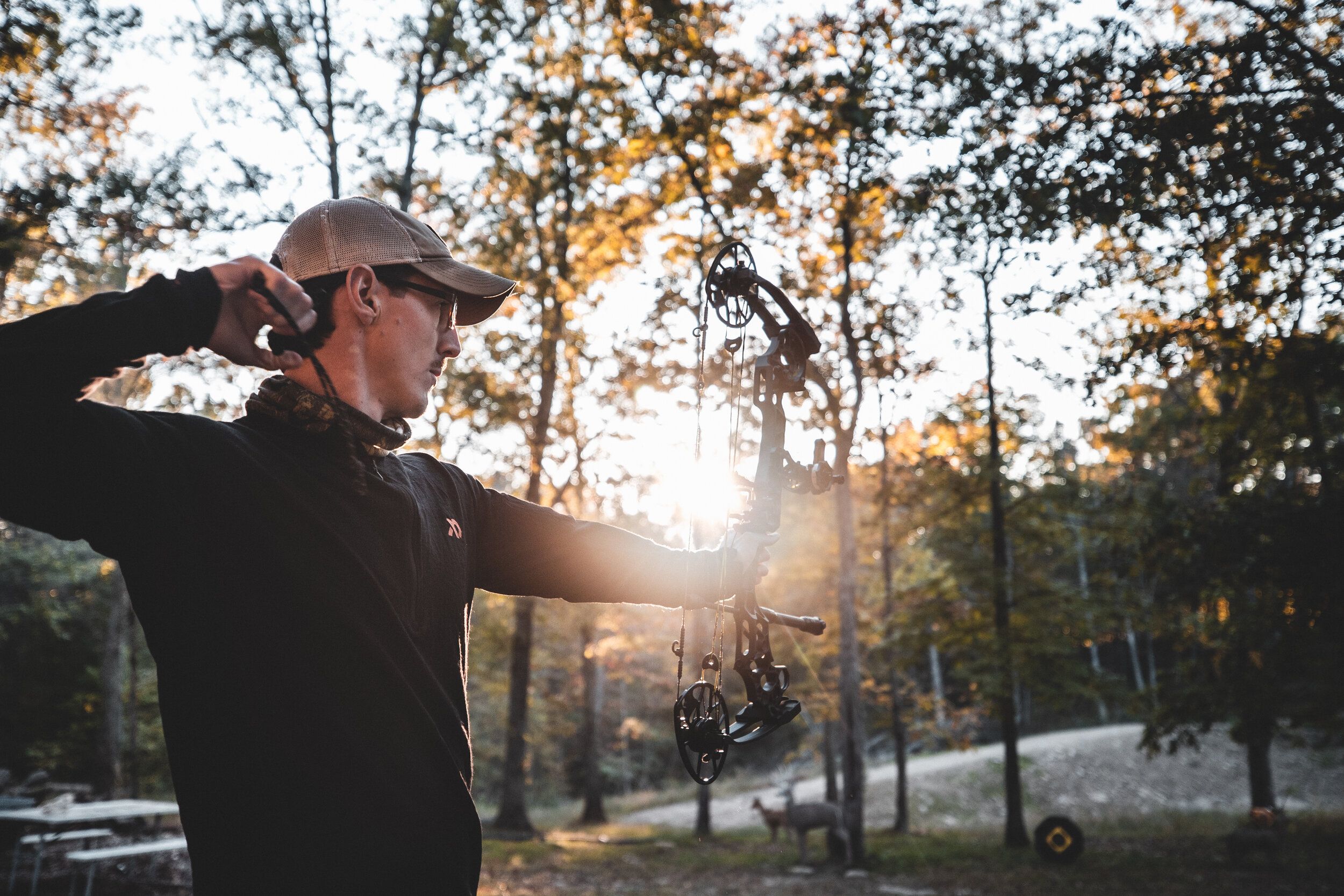 A deer hunter practices shooting a bow. 