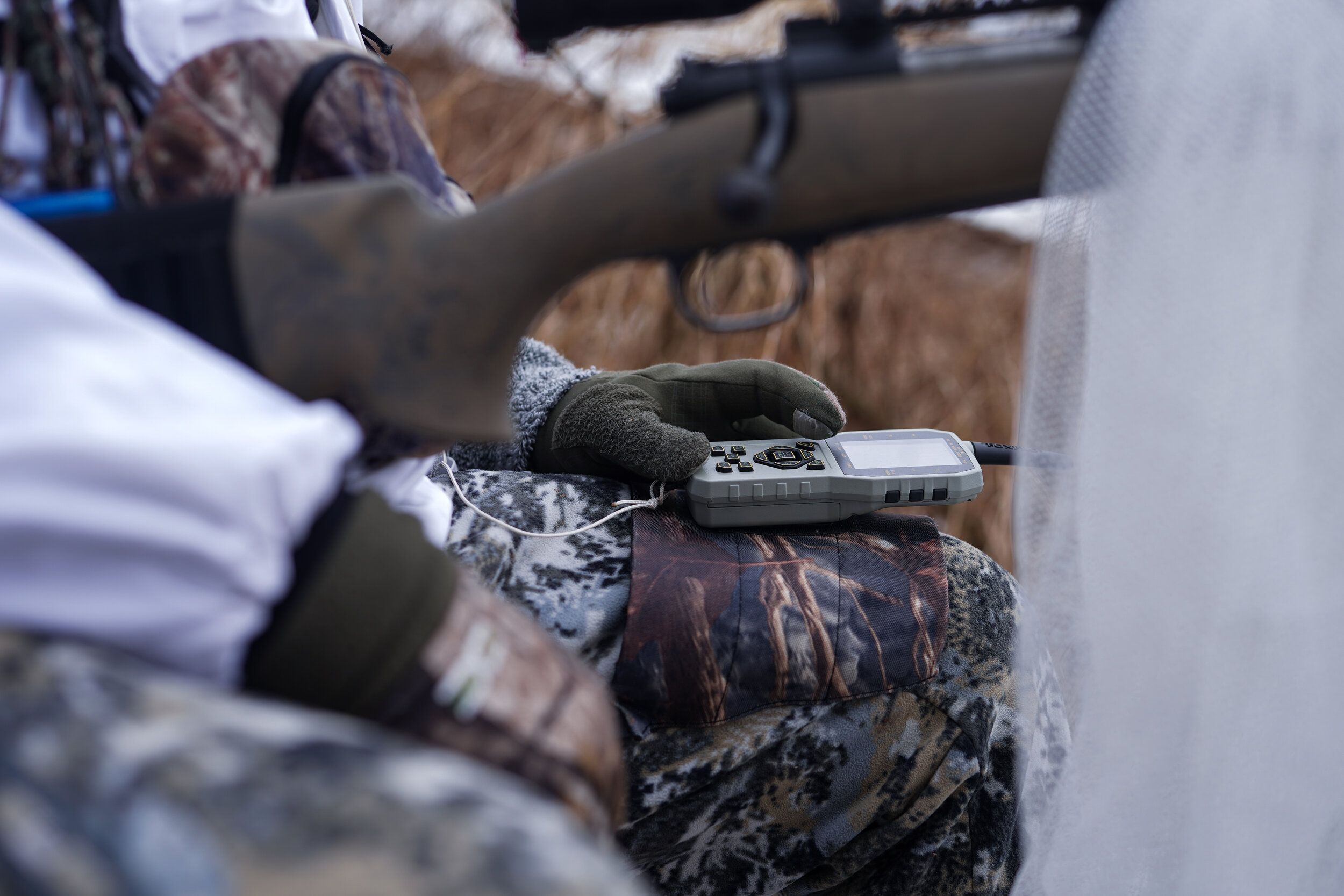 A hunter using a coyote call while coyote hunting. 