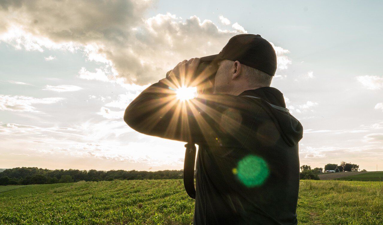 Jeff Sturgis scouts land using binoculars, whitetail habitat concept. 