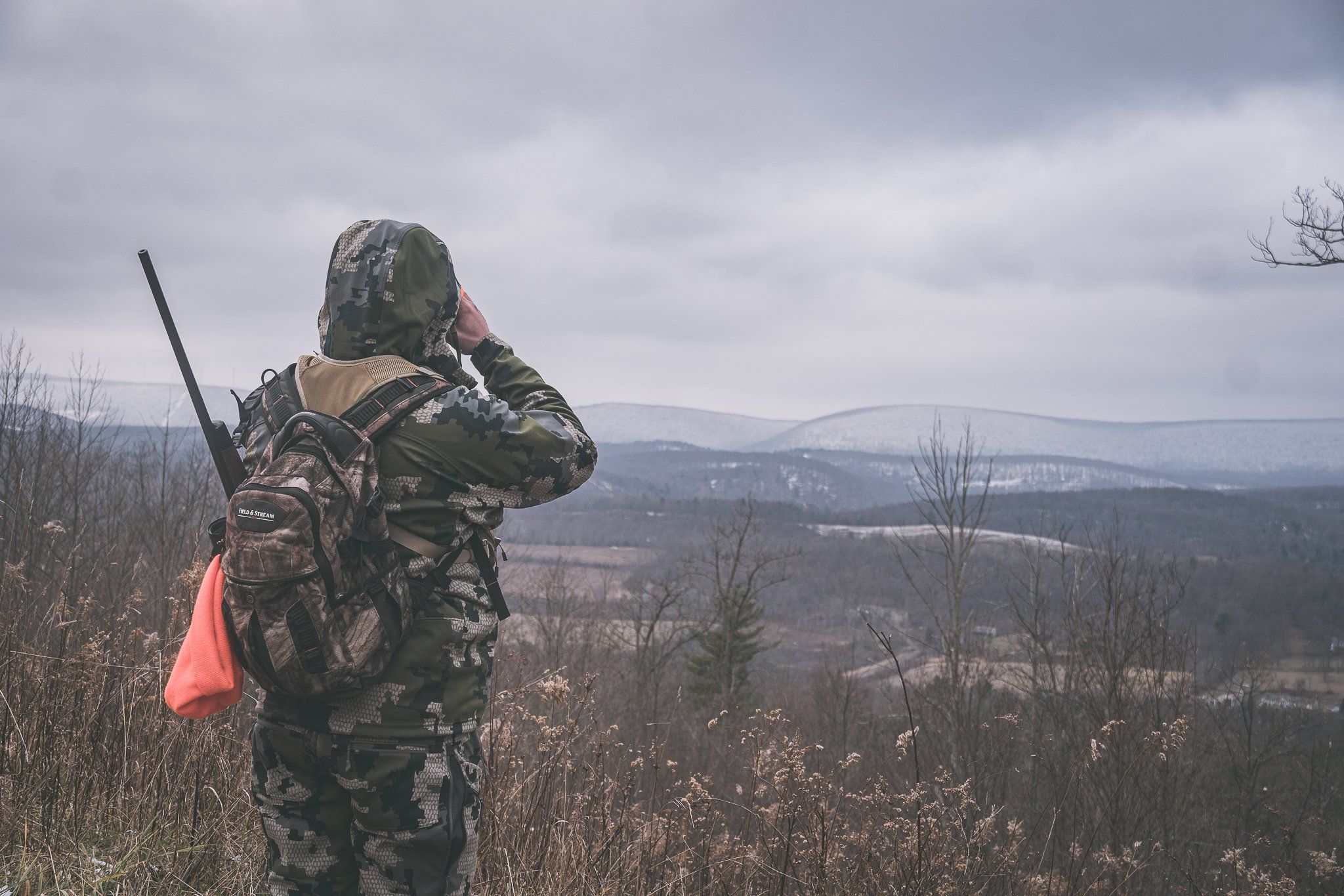 A hunter scouting on a ridge, stalking the rut concept. 