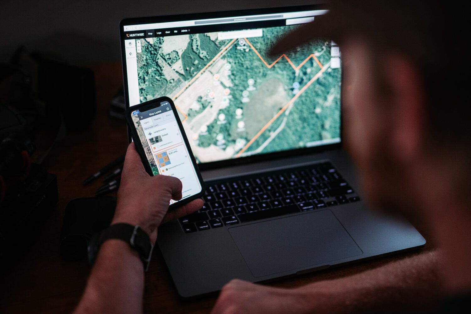 A hunter uses HuntWise on a phone and laptop, scouting for deer concept. 