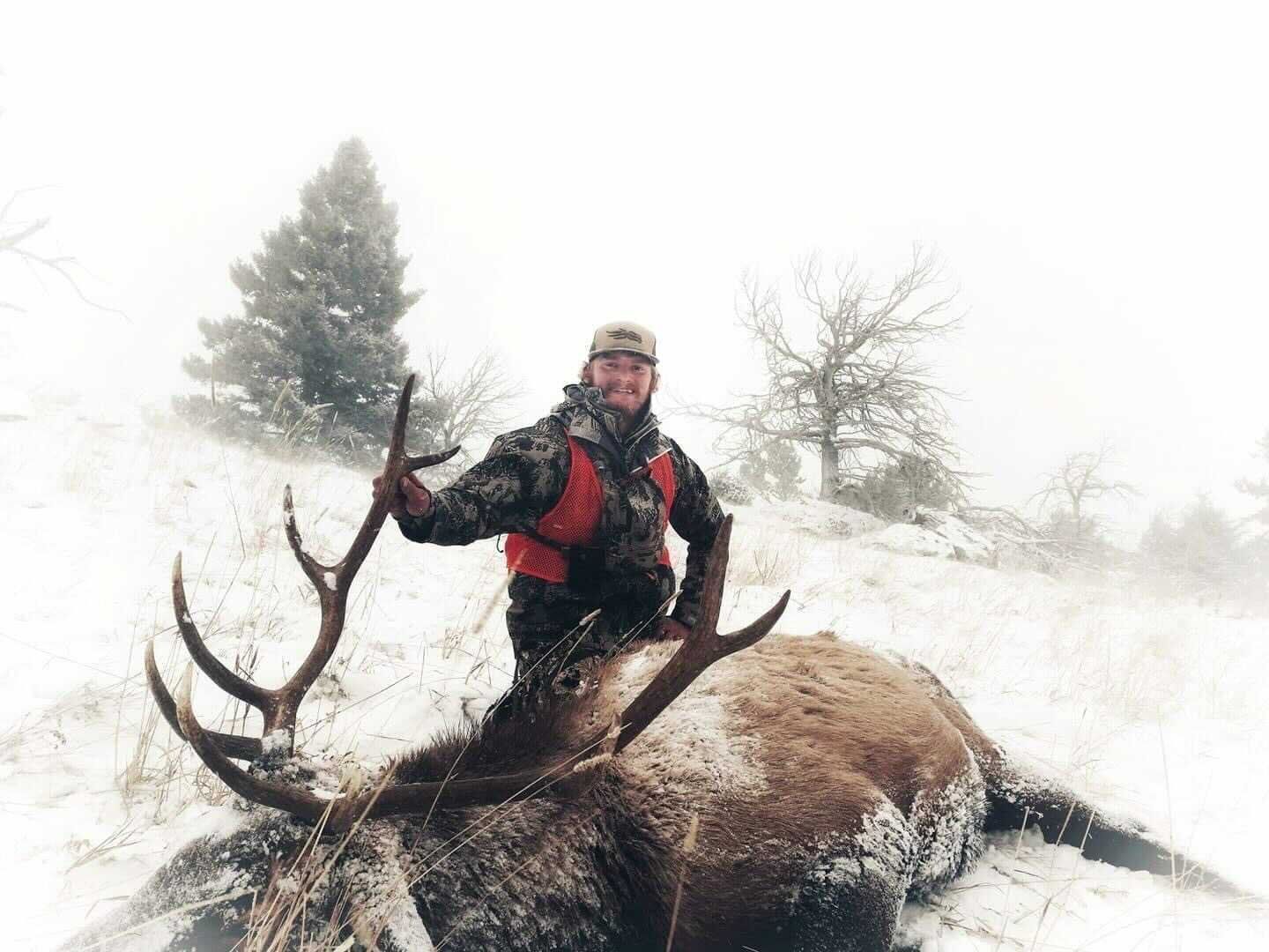 Joe Griffen in the snow with a downed elk. 