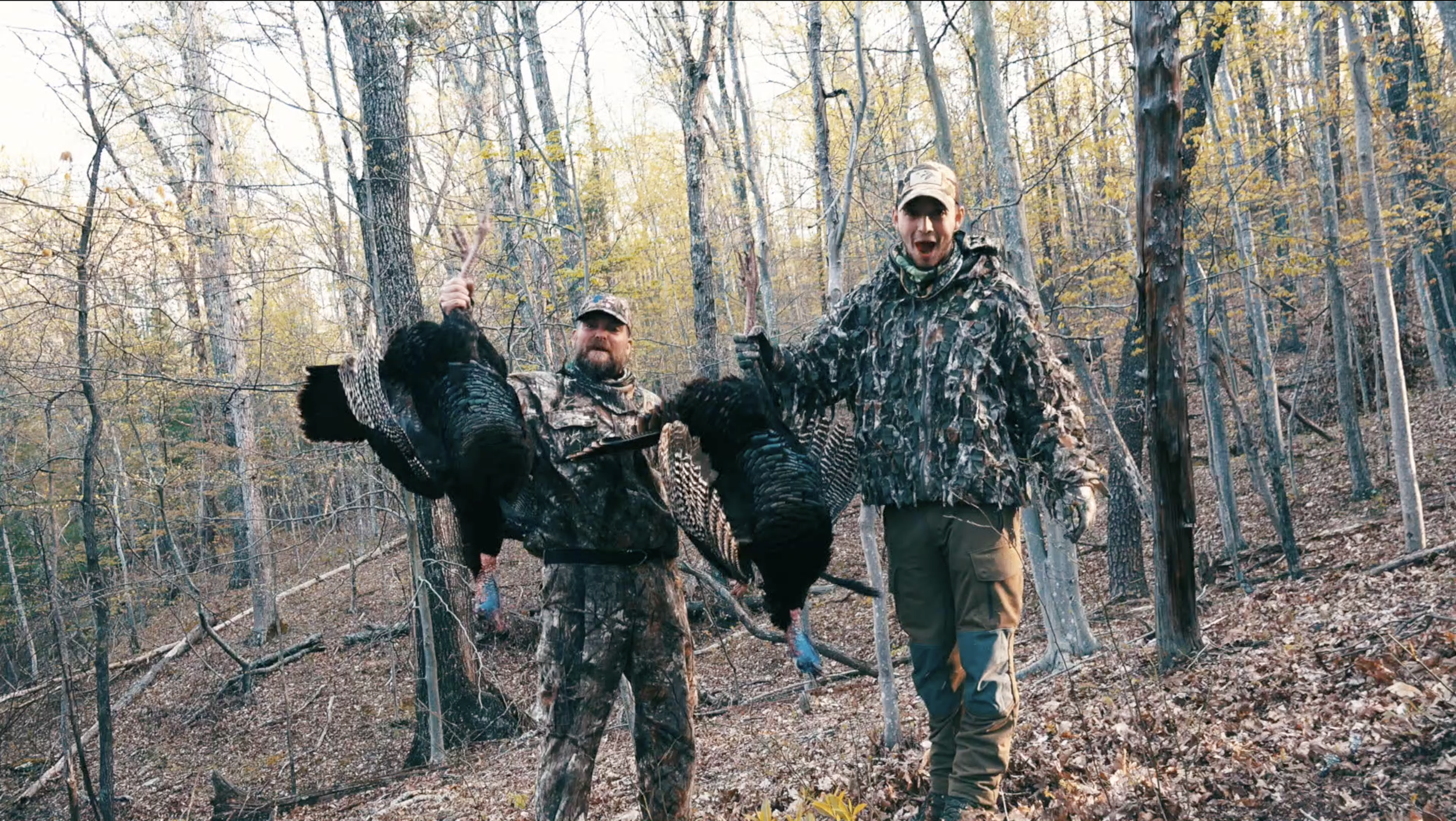 Two members of The Untamed hunters hold turkeys after a hunt. 