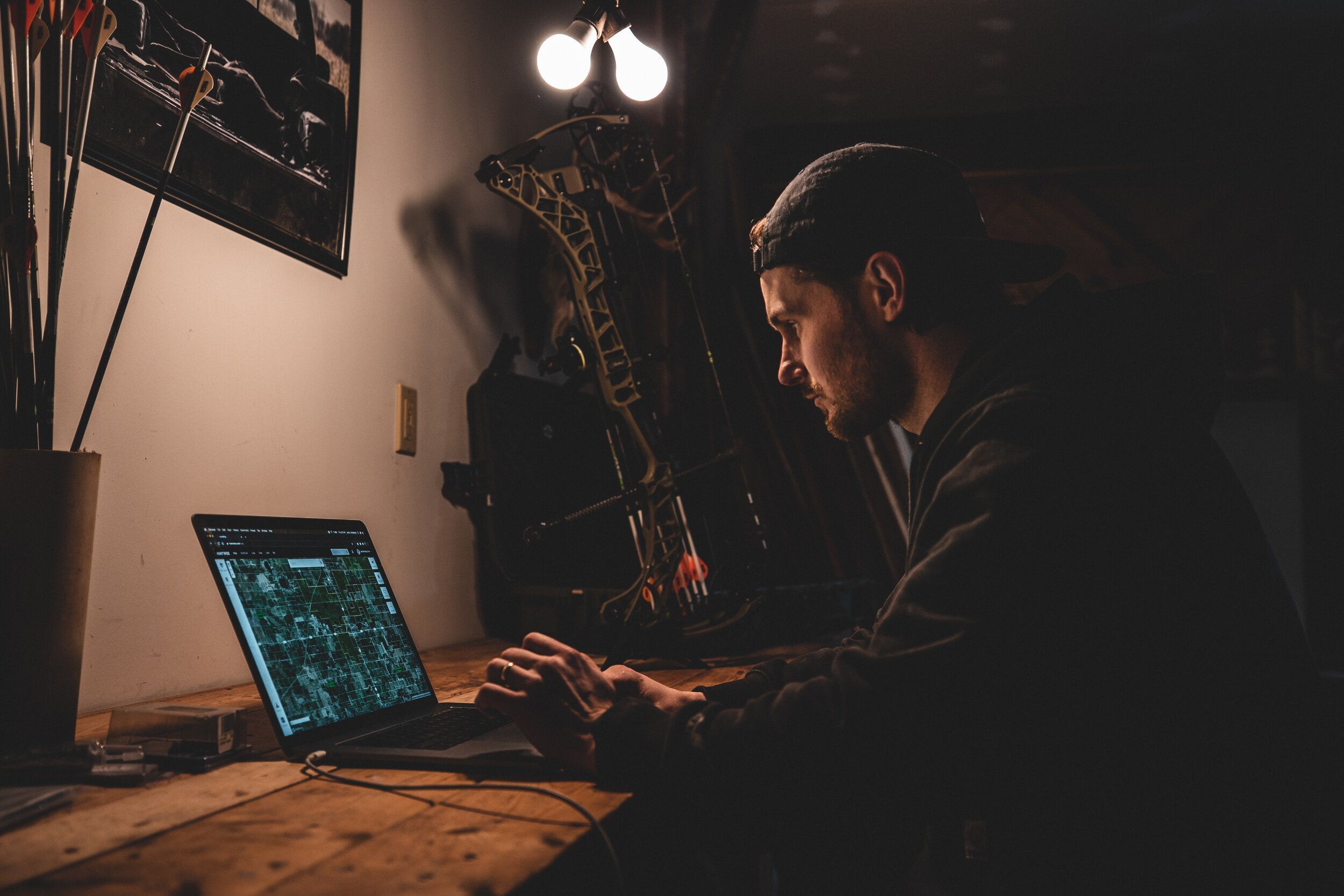 Hunter using HuntWise on a laptop to scout land, turkey hunting app concept. 