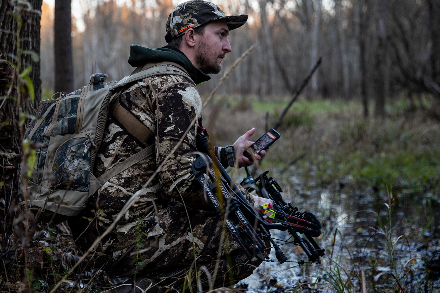 A hunter with camera equipment using HuntWise in the field, hunting influencer concept. 